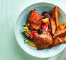 Cajun chicken and sweet potato chips in a blue bowl