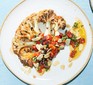 Cauliflower steaks with roasted red pepper & olive salsa served on a plate