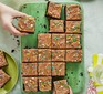 Chocolate cake with sprinkles cut into squares on board