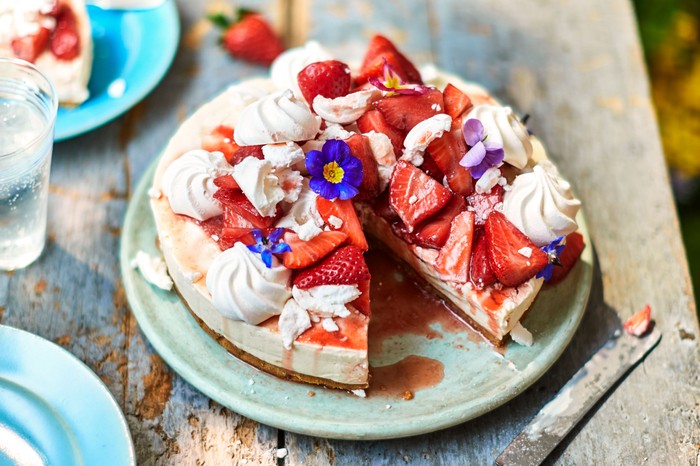 Cheesecake with flowers and strawberries on top