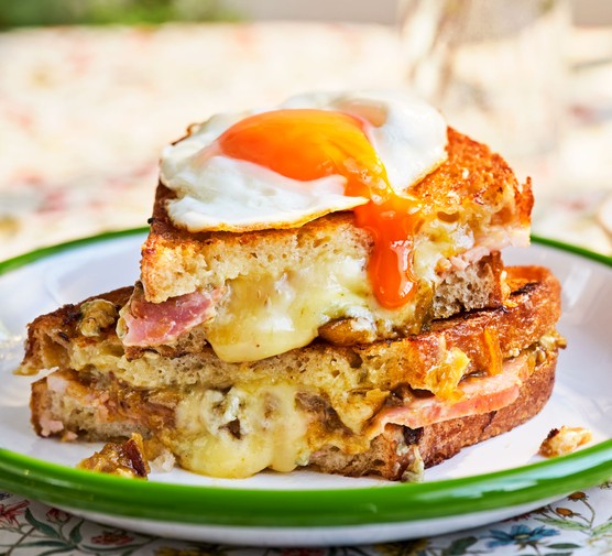 Blue cheese and ham toastie topped with a fried egg served on a plate