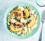 A plate with feta & peach couscous and a fork alongside