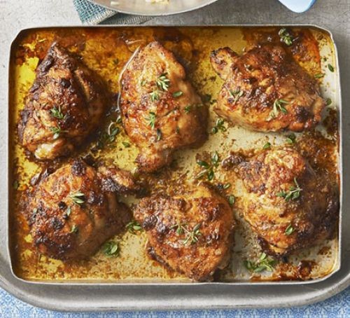 Jerk chicken and sauces on a roasting tray