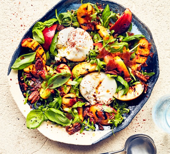 grilled nectarine and burrata salad on a blue serving plate