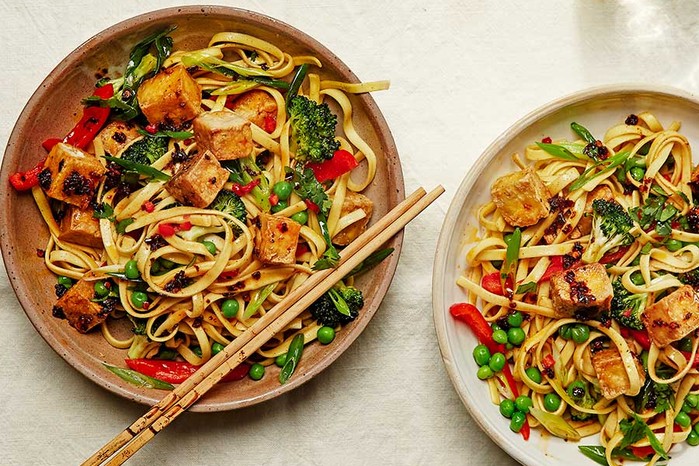 Two bowls of noodles with crispy tofu with peas