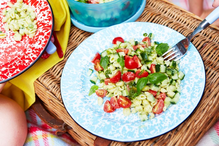 Pesto pasta salad with tomatoes and basil on a plate