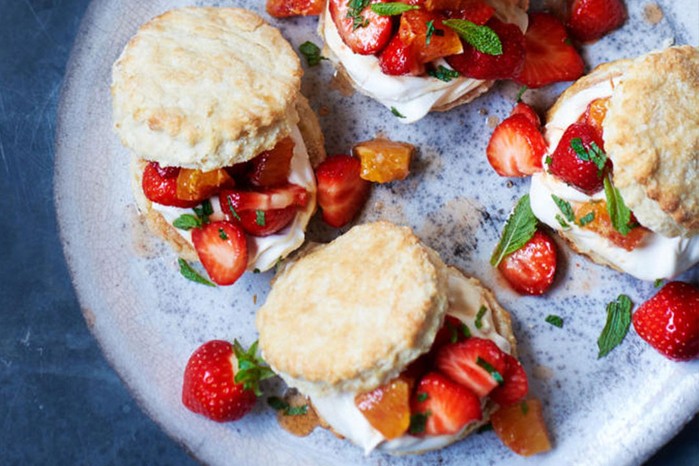 Scones with strawberries and cream on a blue plate