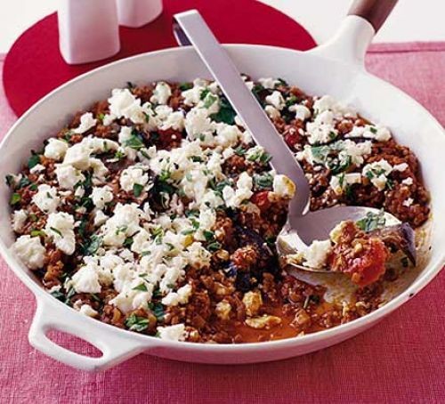 Moussaka topped with feta cheese in a round dish