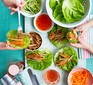 Two people assembling sticky pork lettuce wraps